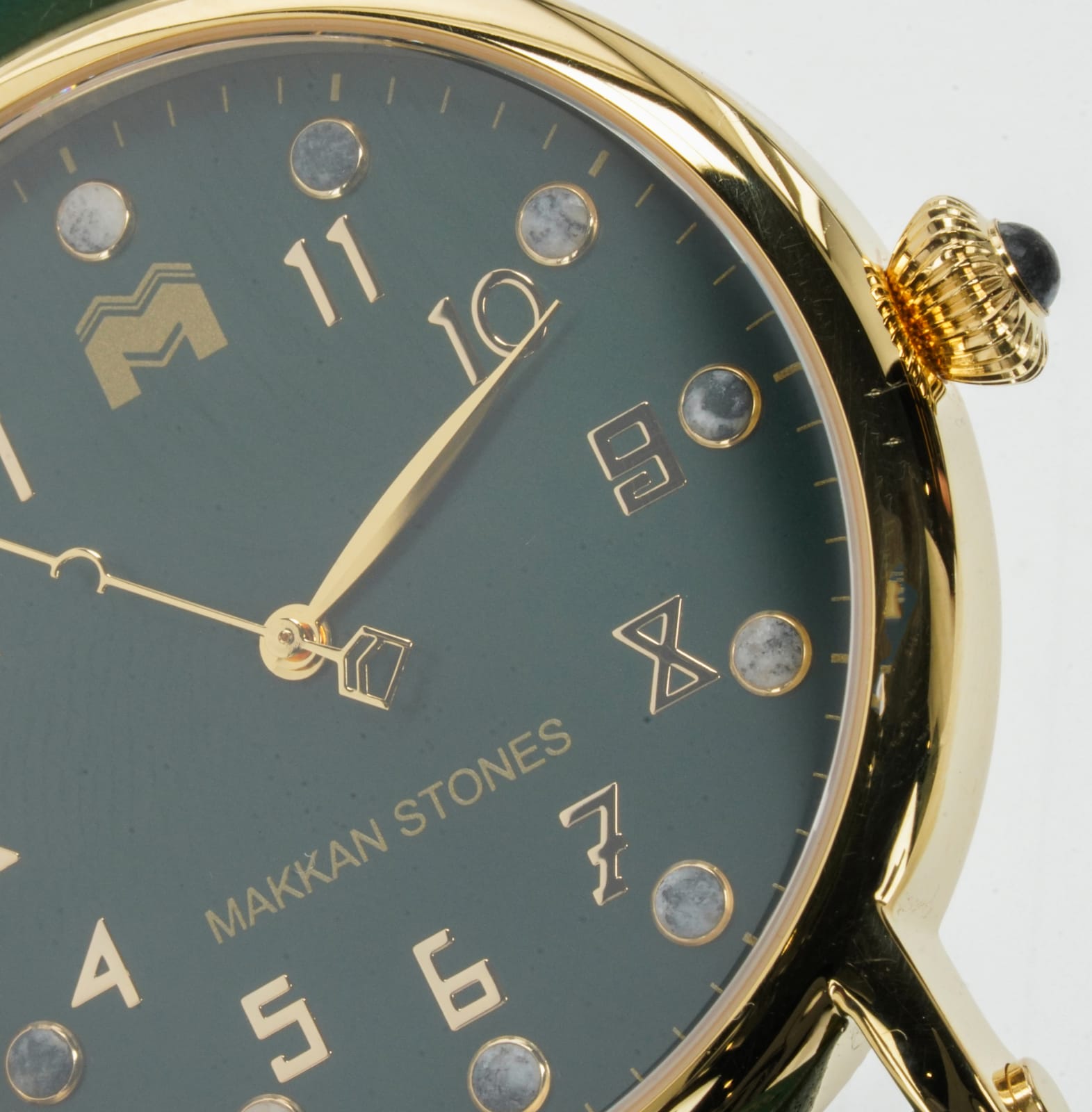 Macro of the Madinah Dome dial: deep green face, gold case and numerals