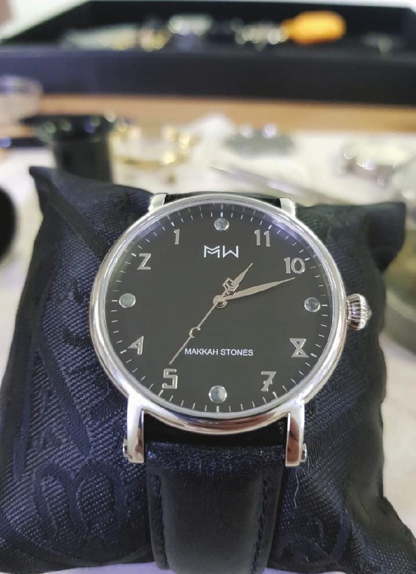 Corners of the Kaaba: black dial watch on dark cloth