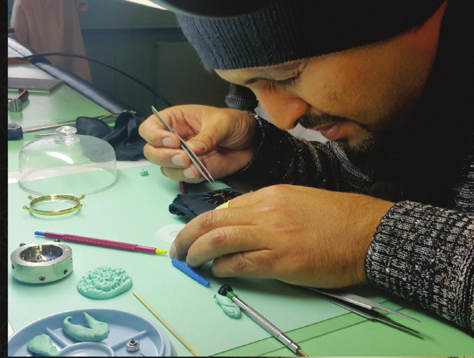 A watchmaker at the bench in the Makkah factory, assembling a movement